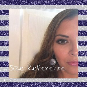 May include: A close-up of a woman's face with a silver earring featuring the text "Addicted to Coffee". The text is in a white font. The earring is a size reference for the product.