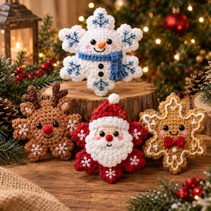 May include: Four crocheted ornaments shaped like snowflakes, featuring a white snowman with a blue scarf, a brown reindeer with antlers, a red Santa Claus with a white beard, and a tan gingerbread person with a red bow tie.