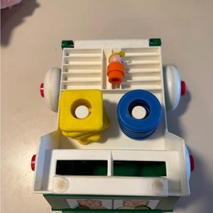 Johnson and Johnson vintage stacking rings pull string truck toy with person