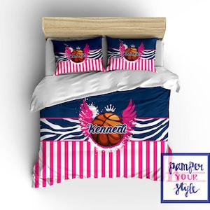 May include: A blue and white zebra print bedding set with a pink and white striped border. The set features a basketball with wings and a crown, and the name "Kennedi" printed on the basketball.