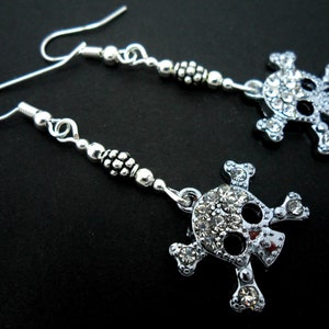 A pair of pretty diamante crystal rhinestone  skull and crossbones dangly earrings.