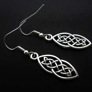 Peut inclure: Une paire de boucles d'oreilles pendantes en argent avec un motif de nœud celtique. Les boucles d'oreilles sont en forme de larme et ont un crochet en argent.