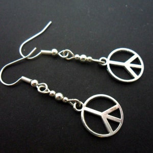A pair of cute little tibetan silver peace sign dangly earrings.