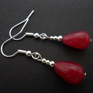 Peut inclure: Une paire de boucles d'oreilles pendantes en argent avec des perles de pierres précieuses rouges en forme de goutte.