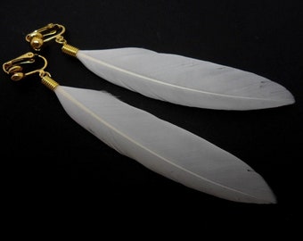 Une paire de couleur dorée et plume blanche clip boucles d’oreilles.