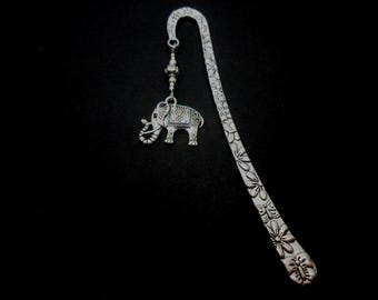 May include: Silver bookmark featuring an elephant charm and floral design. The bookmark is made of metal and has a silver finish.