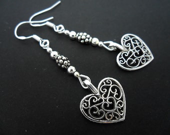 A pair of hand made heart themed  tibetan silver dangly earrings with 925 solid silver hooks.
