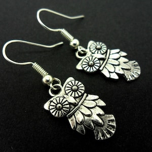 A pair of cute little tibetan silver owl themed  dangly earrings.