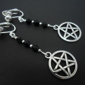 May include: A pair of silver clip-on earrings with black crystal beads and a silver pentagram charm.