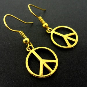 A pair of cute little gold tone  peace sign dangly earrings.