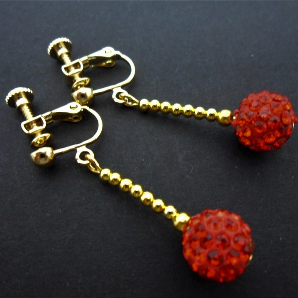 Un par de bonitos aretes colgantes de rosca estilo shamballa en color rojo.
