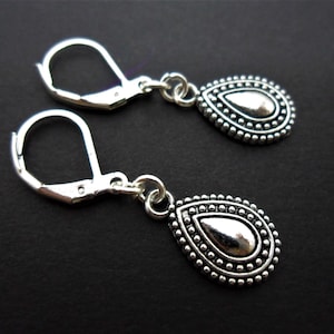 May include: Silver teardrop earrings with a beaded border and a leverback closure.