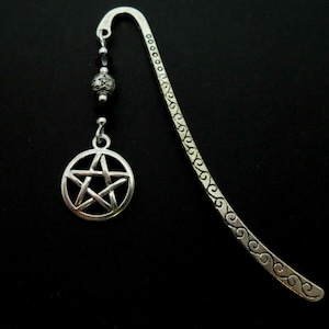 May include: Silver bookmark with a pentagram charm and black beads. The bookmark has a decorative, swirling design.