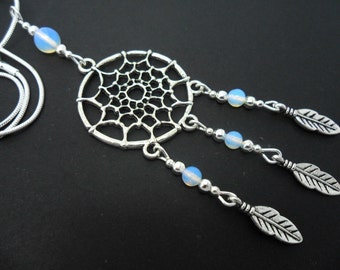 May include: Silver dreamcatcher necklace with opal beads and feather charms. The necklace is on a silver chain.