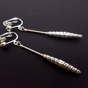 A pair of hand made tibetan silver slim long dangly clip on earrings.