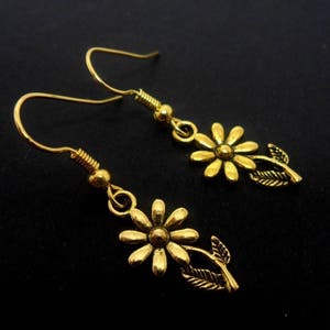 Une paire d’or fait à la main couleur mignonne petite fleur sur le thème pendantes boucles d’oreilles.