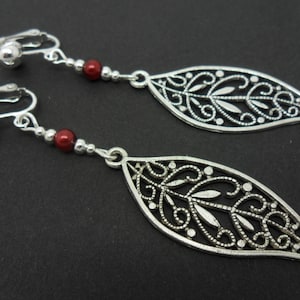 Um par de lindos brincos longos pendurados com tema de prata tibetana e folha de contas vermelhas.