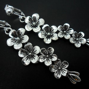 A pair of pretty tibetan silver flower  themed  dangly clip on earrings.