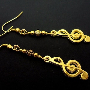 A pair of cute gold colour treble clef musical note  themed  dangly earrings.