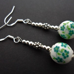 Une paire de boucles d&#39;oreilles pendantes en porcelaine verte et blanche faites à la main avec des crochets en argent massif 925.