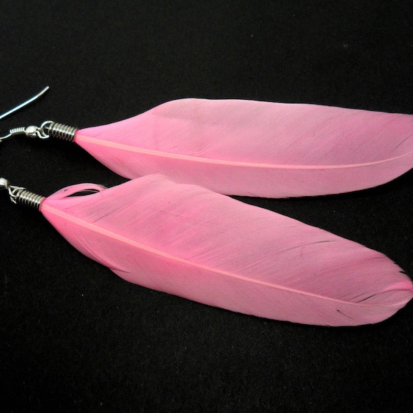 A pair of long pink feather dangly earrings.