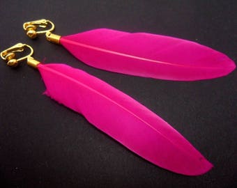 A pair of long bright pink feather dangly clip on earrings.