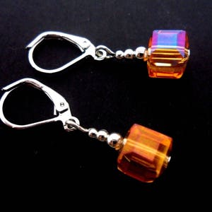 Un paio di graziosi orecchini pendenti fatti a mano in argento tibetano con perline cubiche di cristallo color ambra/arancione, con chiusura a gancio. Nuovi.