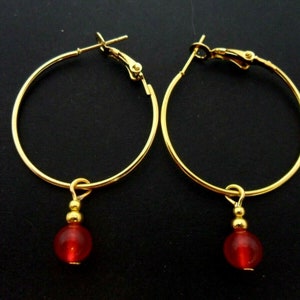 A pair of gold colour 30mm 1" hoop and red jade bead earrings.