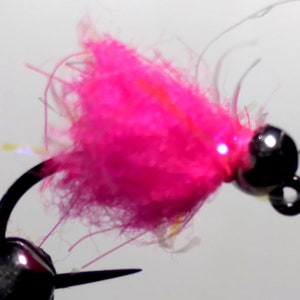 May include: A pink fly tying material with a black bead head. The fly is tied on a hook and is ready to be used for fishing.