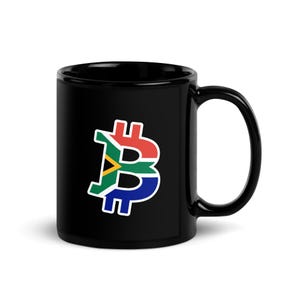 Może przedstawiać: Czarny ceramiczny kubek z grafiką symbolu Bitcoina wypełnioną kolorami i wzorem flagi Republiki Południowej Afryki. Projekt zawiera biały kontur wokół symbolu, który jest wyśrodkowany na przedniej części cylindrycznego kubka.