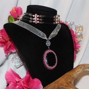 Kaboszon z koralików z czarnego onyksu, akcentowany różem i kryształem, pokazany tutaj w połączeniu z naszyjnikiem choker,