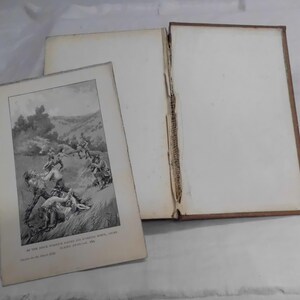 May include: An open antique book with a sepia-toned illustration of a battle scene. The book's pages are off-white, and the cover is a dark brown. The illustration depicts figures in a grassy field, engaged in combat. The text at the bottom of the illustration is partially visible.