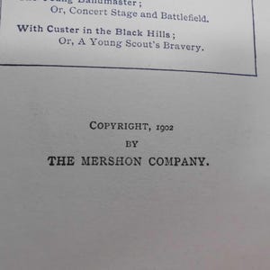 May include: A close-up of a printed page with text. The text includes the phrases "With Custer in the Black Hills" and "A Young Scout's Bravery." The copyright information indicates the year 1902 and "The Mershon Company."