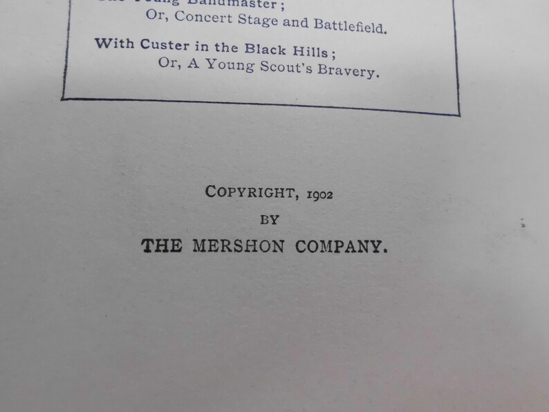 May include: A close-up of a printed page with text. The text includes the phrases "With Custer in the Black Hills" and "A Young Scout's Bravery." The copyright information indicates the year 1902 and "The Mershon Company."