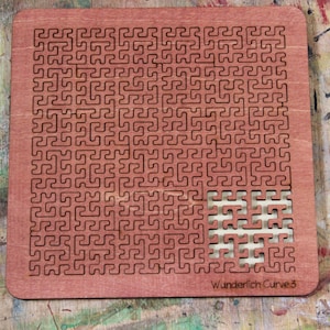 May include: A reddish-brown wooden puzzle with a complex, repeating pattern of interconnected lines. A section of the puzzle is removed, revealing the interlocking pieces. The text "Wunderlich Curve 3" is printed on the bottom right corner. The puzzle is on a wooden surface.