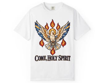 May include: A white short-sleeve t-shirt featuring a central graphic of a dove with wings spread, designed in a stained-glass style with blue, yellow, and orange tones. Flames surround the dove, and the text reads COME, HOLY SPIRIT.