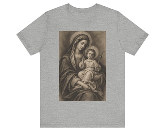 May include: A heather grey short-sleeved t-shirt featuring a central, sepia-toned graphic print of a woman in a head covering holding a child, both depicted with circular halos behind their heads, with the child holding a small cross staff.