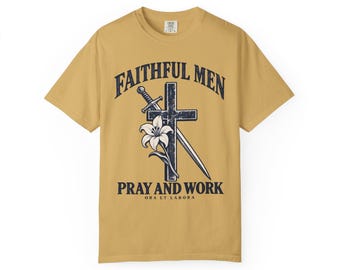 May include: A mustard yellow t-shirt featuring a dark blue graphic of a cross, a sword, and a lily. The text reads FAITHFUL MEN, PRAY AND WORK, and ORA ET LABORA. The design is centered on the chest of the short-sleeved crew neck garment.