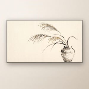 May include: A rectangular wall art piece featuring a black ink wash illustration of tall, feathery grass stalks arranged in a small, rounded ceramic vase. The artwork is set against a light cream background and enclosed in a thin black frame.