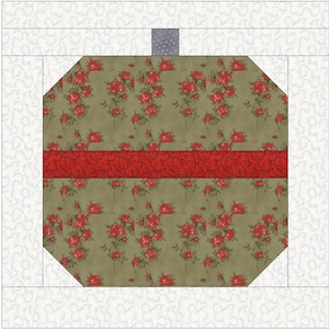 Może przedstawiać: Blok pikowany z centralnym ośmiokątnym kształtem z kwiatowym wzorem czerwonych róż na zielonym tle. Czerwony poziomy pas dzieli kwiatowy wzór. Białe i jasnoniebieskie wzorzyste obramowania otaczają blok.
