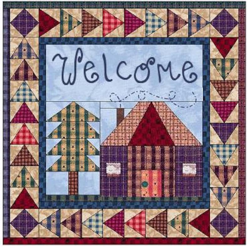 May include: A quilted wall hanging with a blue and white patchwork border. The centre features a blue sky with a house and a tree, and the word "welcome" in a cursive font.