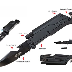 Puede incluir: Cuchillo multiusos negro con hoja dentada, abridor de botellas, luz LED, encendedor, corta cinturones de seguridad y rompe cristales. El cuchillo tiene un bloqueo de la hoja y el texto "WARTECH" est&aacute; impreso en la hoja.