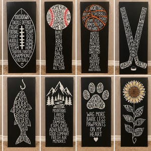 Peut inclure: Une collection de douze panneaux rectangulaires en bois noir avec des motifs typographiques blancs. Les designs incluent une guitare, un ballon de football, de baseball, de basket, des crosses de hockey, un ballon de volley, un cerf, un poisson, une montagne, une patte, un tournesol et un bocal de fleurs.