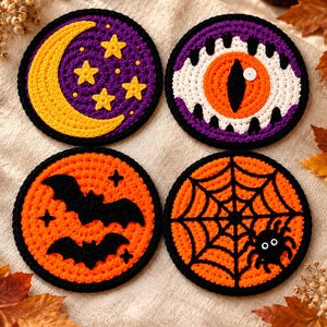 Puede incluir: Cuatro posavasos redondos de ganchillo con diseños de Halloween: una luna creciente amarilla con estrellas sobre fondo morado, un ojo naranja estilizado, dos murciélagos negros sobre fondo naranja y una araña en su telaraña.