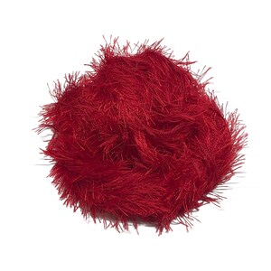 Puede incluir: Una madeja de hilo rojo vibrante con una apariencia difusa y texturizada. El hilo est&aacute; densamente empaquetado, creando un aspecto suave y afelpado. El color rojo brillante es consistente, adecuado para varios proyectos de manualidades.
