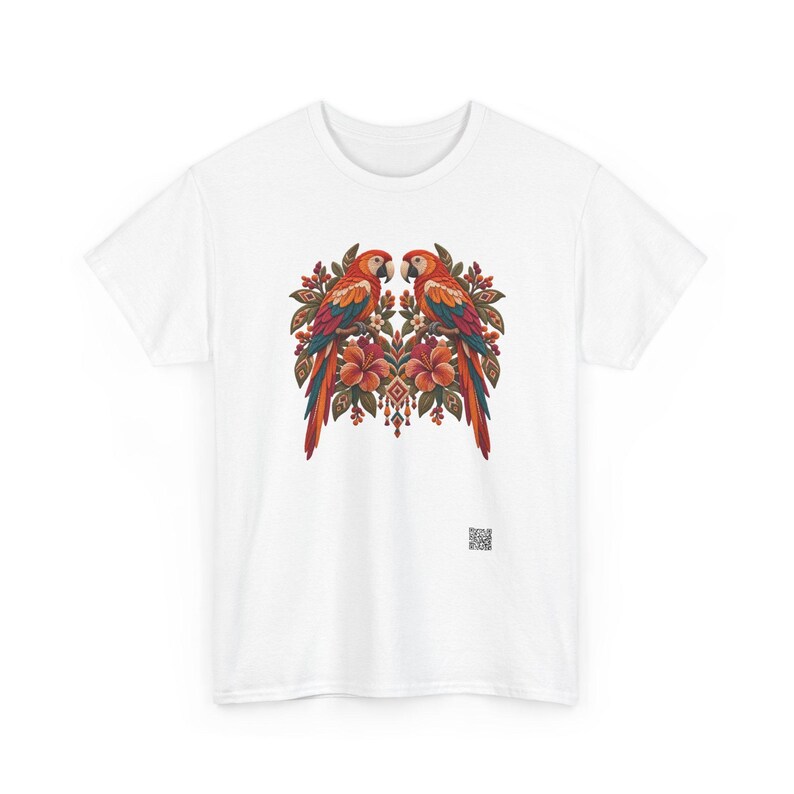May include: A white short-sleeved t-shirt featuring a central graphic of two symmetrical parrots perched among tropical flowers and foliage in shades of red, orange, and green, with a small square QR code printed near the bottom right.