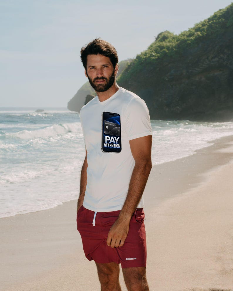 May include: A white short-sleeved t-shirt featuring a graphic of a smartphone displaying a credit card and the text PAY ATTENTION, paired with maroon shorts that have a white drawstring and a small white logo on the lower left leg.