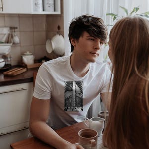 Puede incluir: Una camiseta blanca de manga corta con un gr&aacute;fico rectangular de una radiograf&iacute;a del torso humano. El gr&aacute;fico incluye el texto I'M TRANSPARENT. I HIDE NOTHING. La camiseta tiene cuello redondo y una silueta ajustada.
