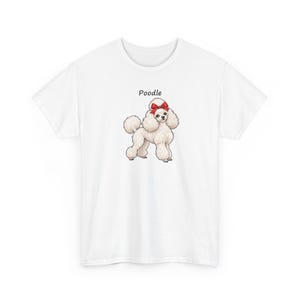 May include: A white short-sleeved t-shirt featuring a centered graphic of a fluffy cream-colored poodle dog with a bright red bow on its head. Above the illustration, the word Poodle is printed in a simple black sans-serif font.