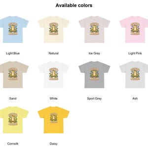 May include: A collection of short-sleeve t-shirts in twelve different colors, including light blue, natural, ice grey, light pink, sand, white, sport grey, ash, cornsilk, and daisy. Each shirt features a graphic of a frog meditating with the text Less Drama More Karma.